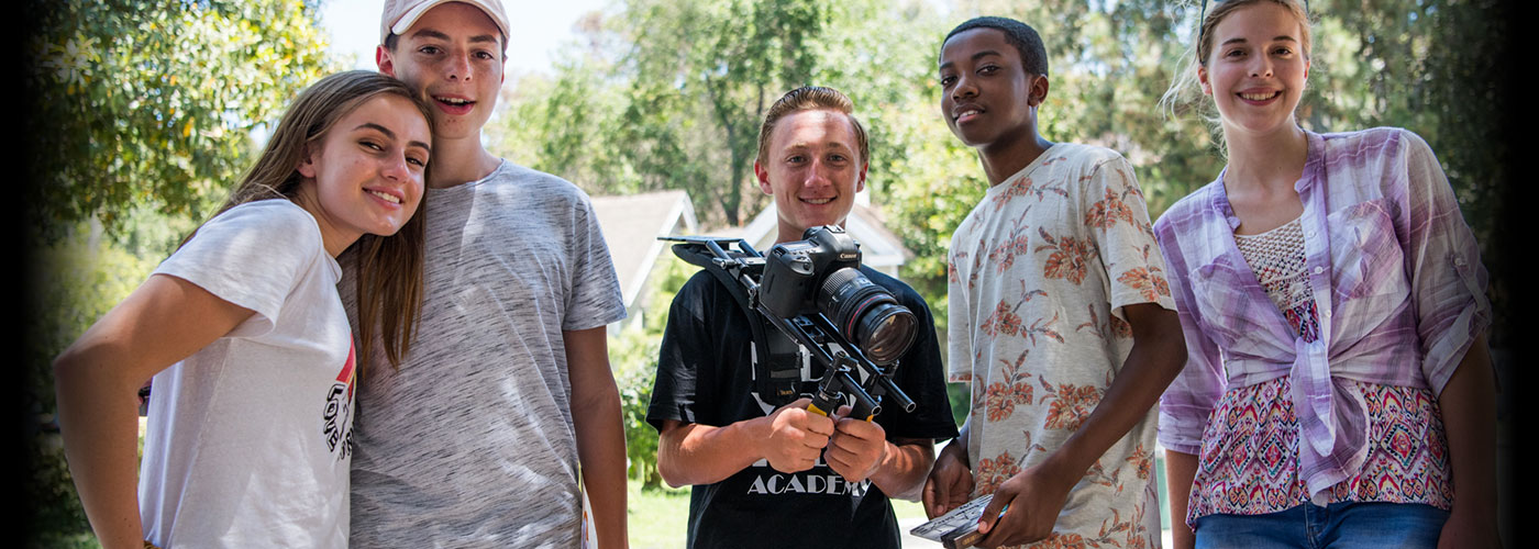 Five smiling NYFA summer camp students pose while one holds a shoulder mounted camera